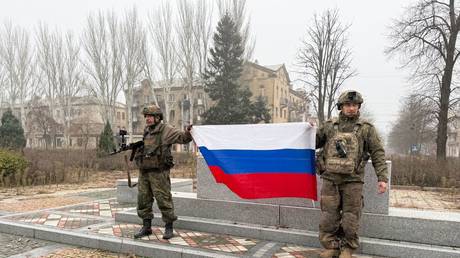 FILE PHOTO: Soldiers pose with a Russian national flag in Krasnoarmeysk, Donetsk People's Republic, Russia, on November 16, 2025.