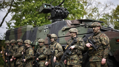 German soldiers stand in front of a Boxer armored personnel carrier, at the Julius Leber Barracks in Berlin on April 24, 2024.